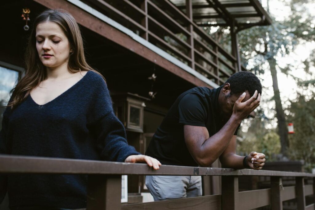 A couple experiencing a breakup on a wooden deck, expressing sadness and separation.