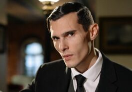 Mysterious man in suit exudes noir vibes in dimly lit room.