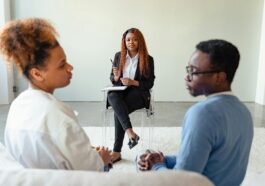 Therapist mediating a counseling session for a couple seeking guidance indoors.