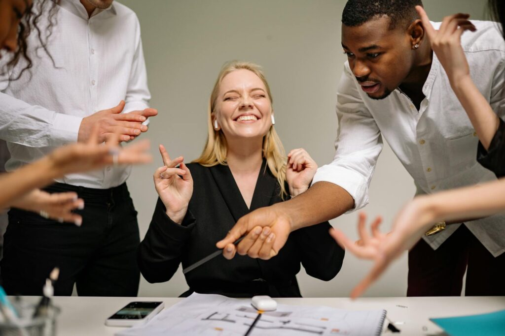 A diverse team engaging in a lively office discussion, showcasing teamwork and collaboration.