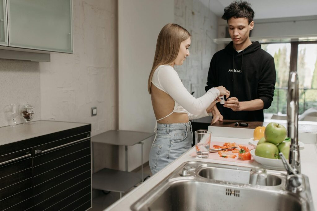 A couple preparing food at home, enjoying time together in a modern kitchen.