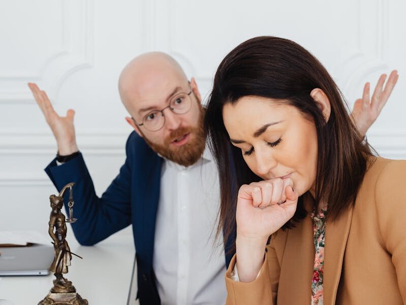 Upset couple arguing indoors, emotional tension and conflict in a legal setting.