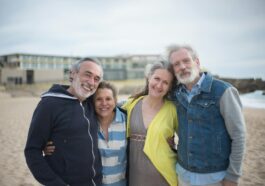 A cheerful group of mature friends enjoying a day at the beach in Portugal, showcasing togetherness.
