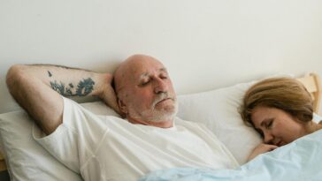 Peaceful elderly couple sleeping together in bed, showing relaxation and comfort.