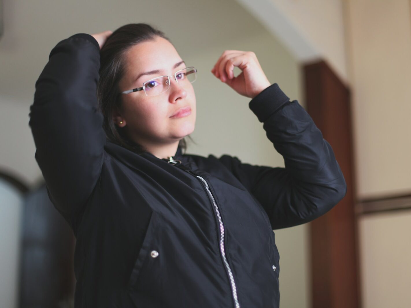 woman in black jacket wearing white earbuds