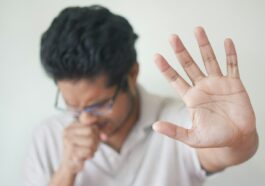 a man holding his hand up in front of his face
