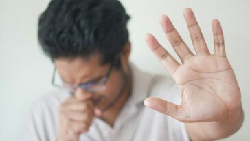 a man holding his hand up in front of his face
