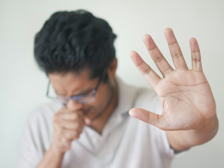 a man holding his hand up in front of his face