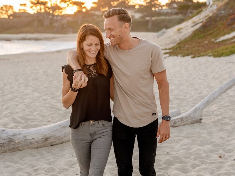 man and woman standing on beach during daytime