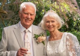 Elderly couple in wedding attire holding hands outdoors