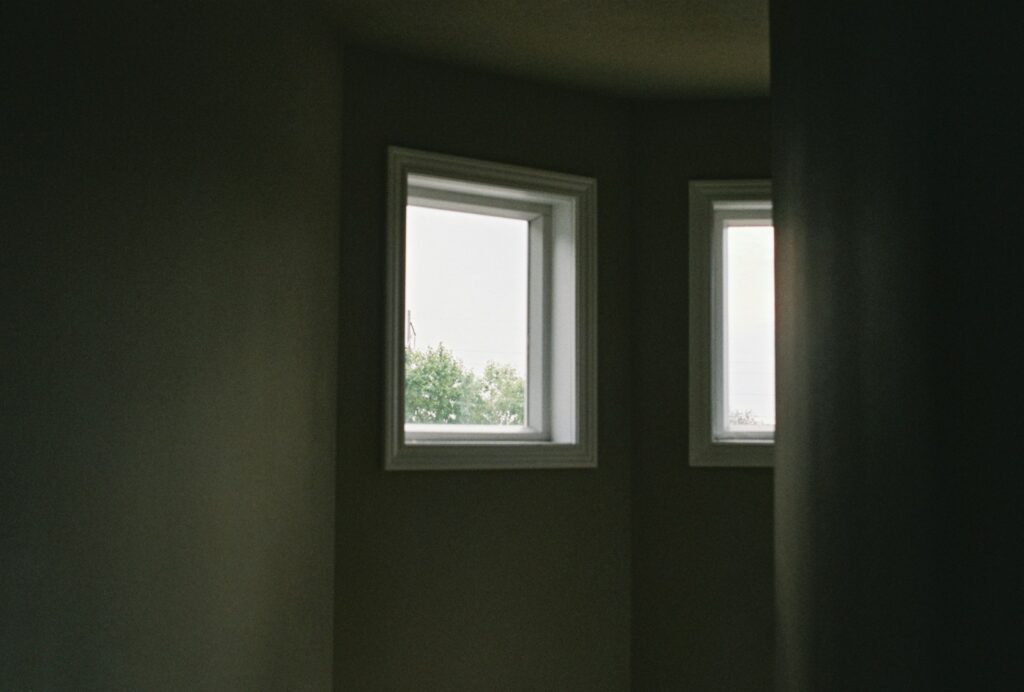a room with two windows and a toilet