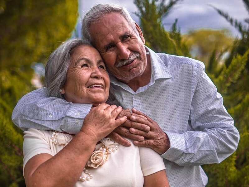 man in white dress shirt hugging woman in white dress