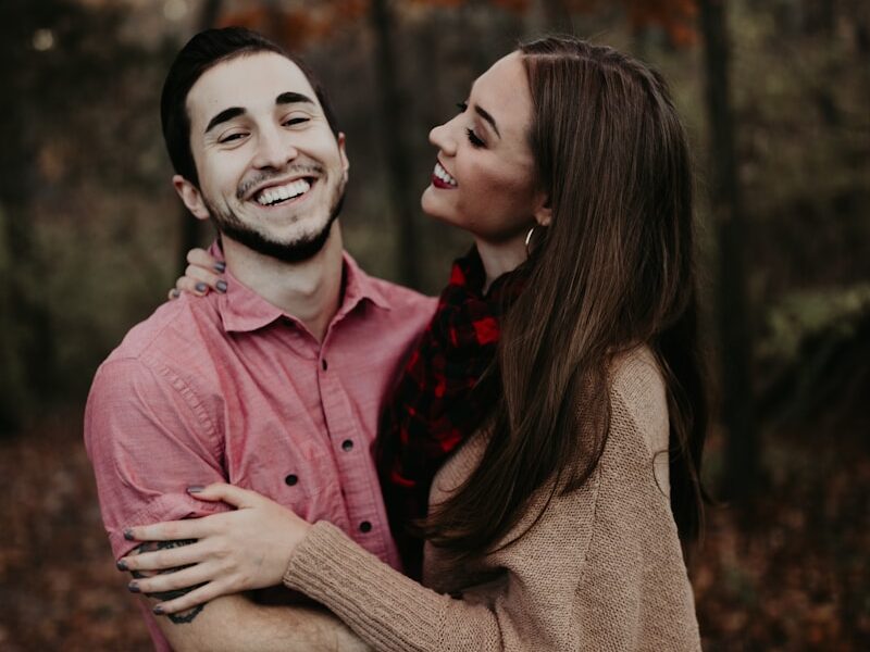 woman hugging man selective focus photography