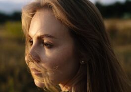 Young woman with windblown hair in a field