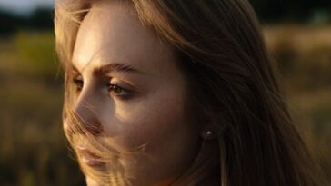 Young woman with windblown hair in a field