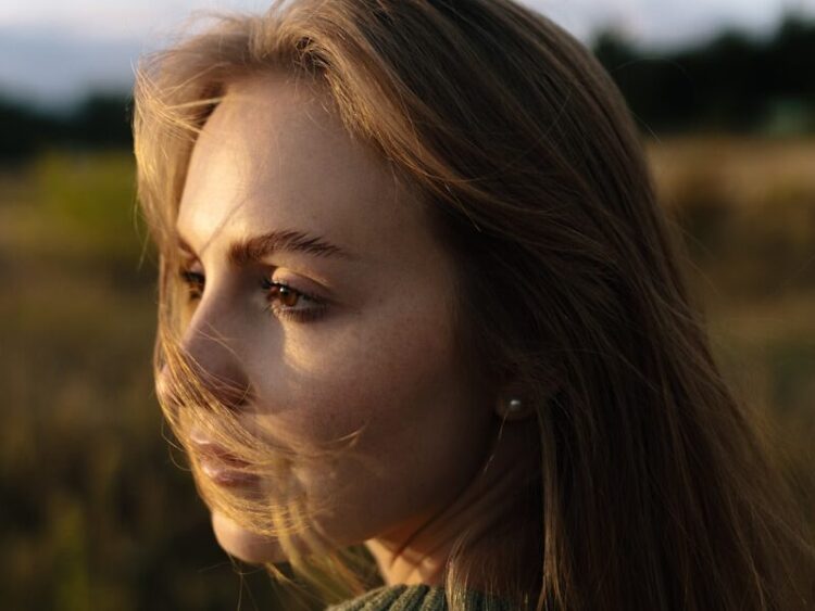 Young woman with windblown hair in a field