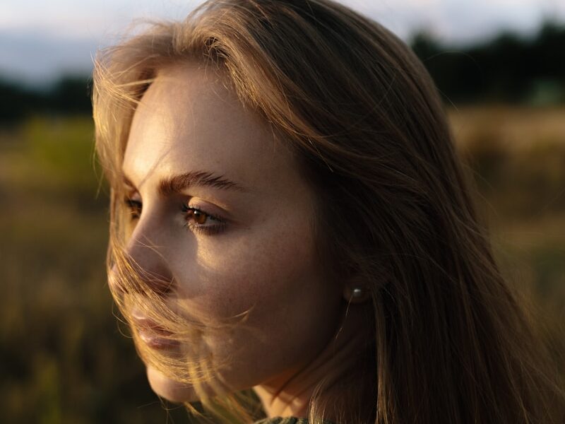 Young woman with windblown hair in a field