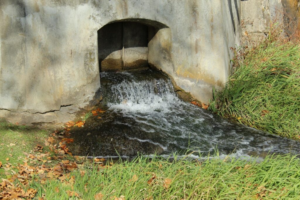 a small waterfall in a stone tunnel