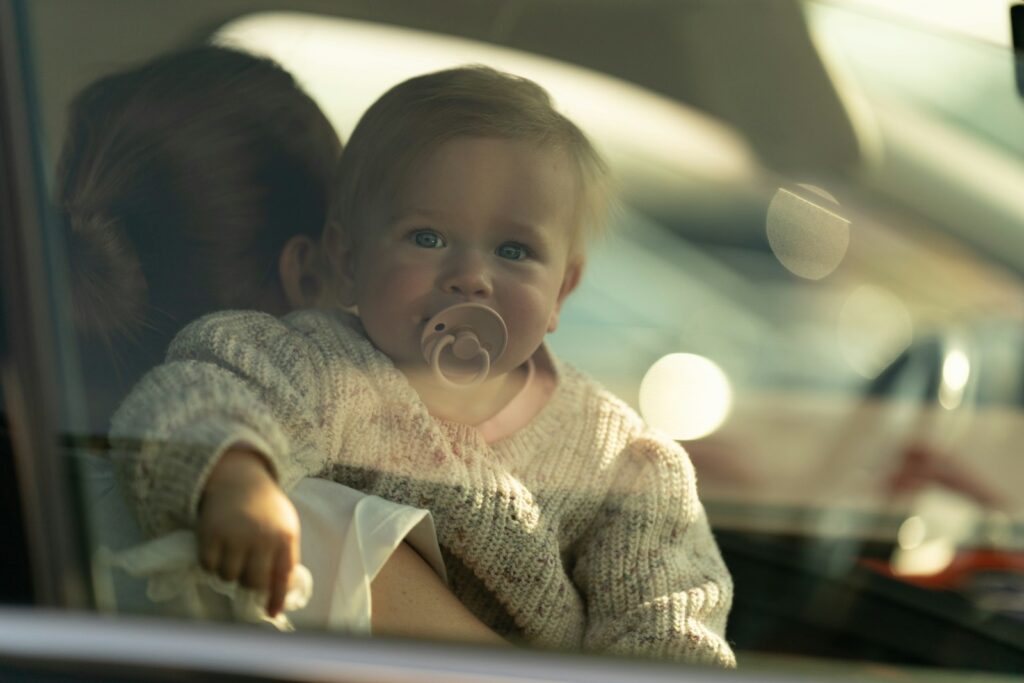 a baby sitting in a car with a pacifier in its mouth
