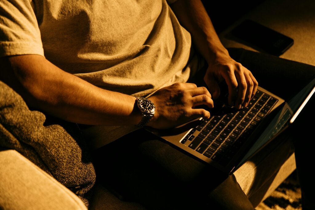 a man sitting on a couch using a laptop computer