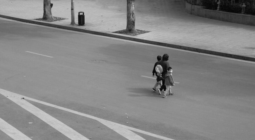 a couple of people walking across a street