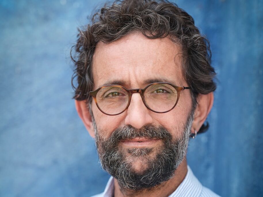 a man with a beard and glasses posing for a picture