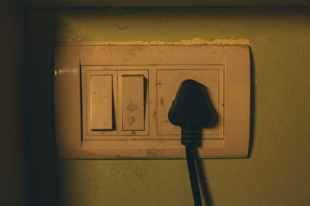 Electrical outlet with a black plug inserted.