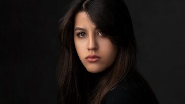 a woman sitting on top of a wooden table