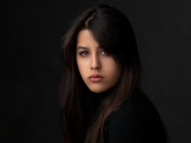 a woman sitting on top of a wooden table