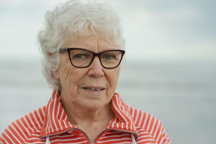 An elderly woman smiles at the camera.