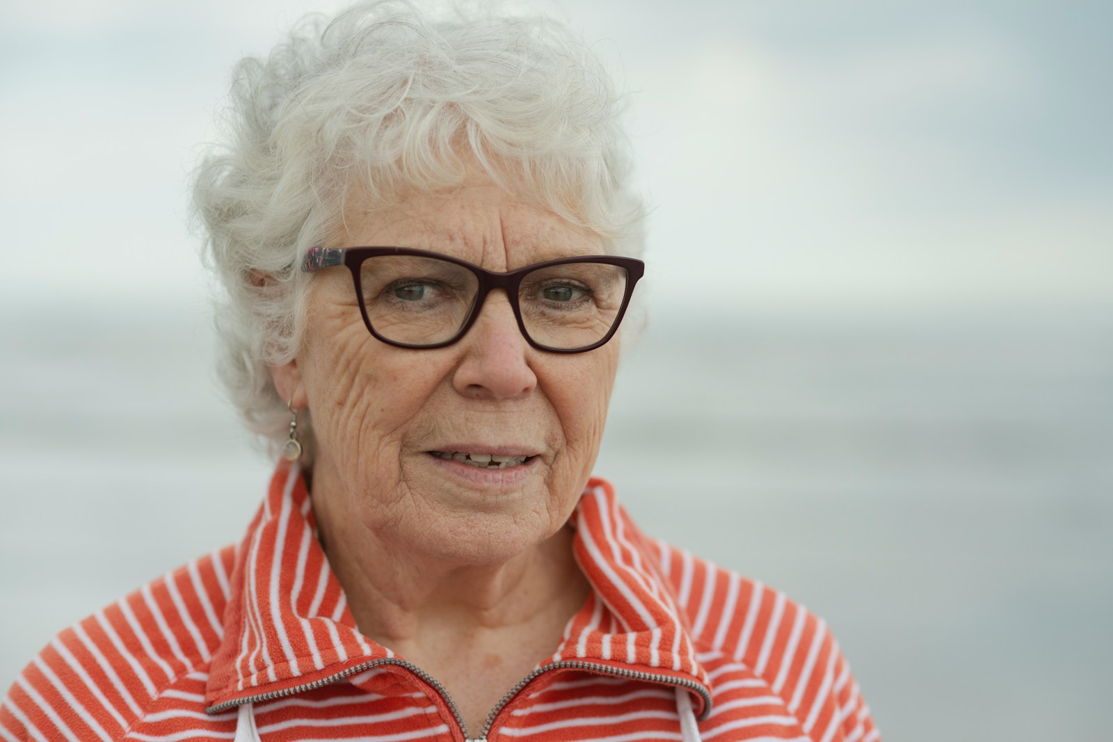 An elderly woman smiles at the camera.