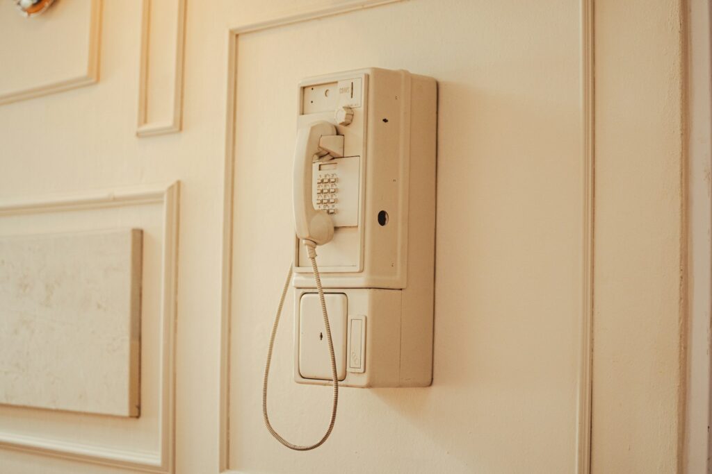 an old phone is hanging on the wall