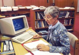 woman sitting at desk with desktop computer