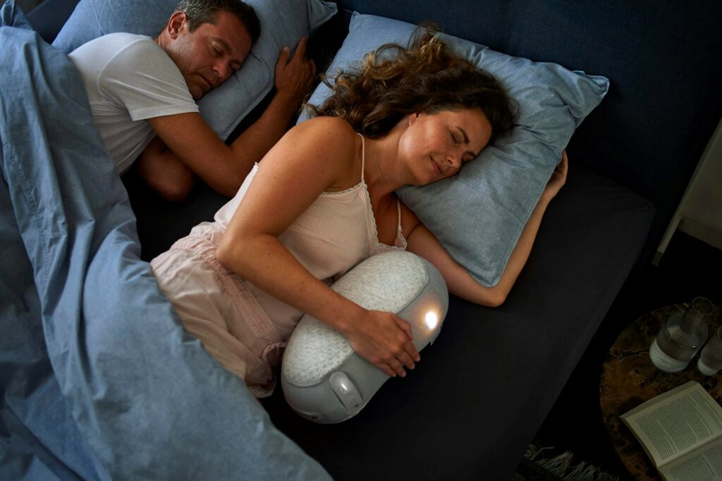 woman in white tank top lying on bed beside man in black shirt
