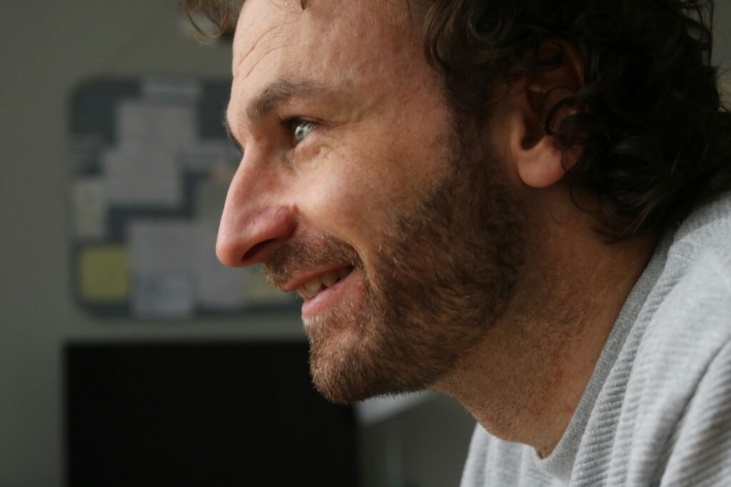 Man with beard smiling looking to the side