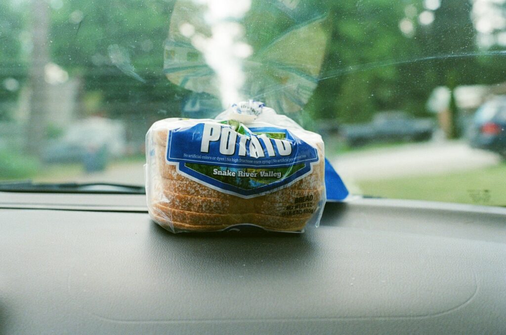 A bag of bread sitting on the dashboard of a car