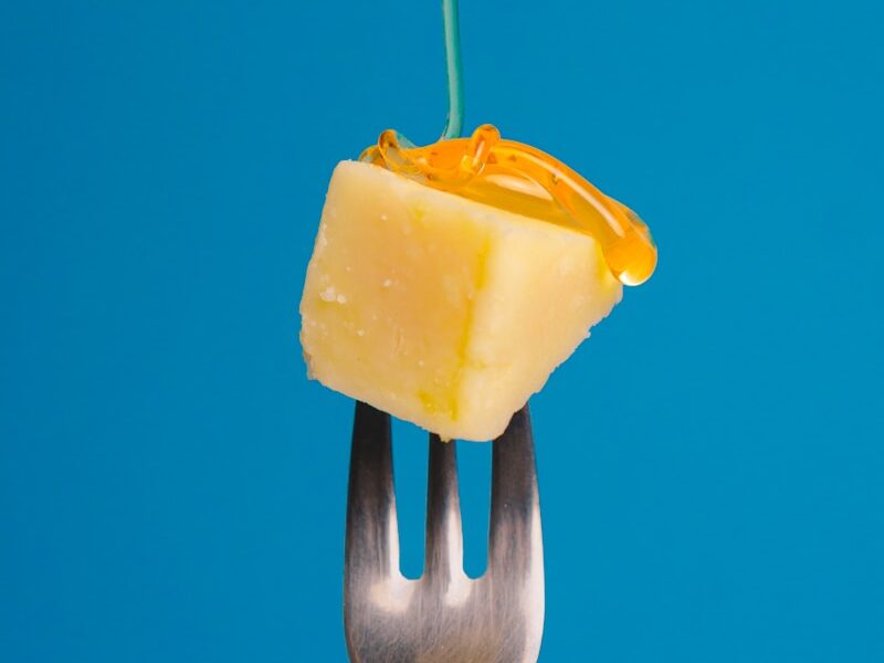 a fork with a piece of cheese on top of it