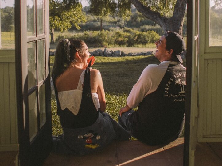 woman and man sitting near opened door