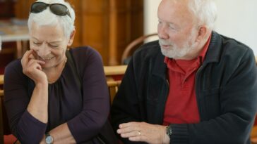 An older couple is talking and smiling.
