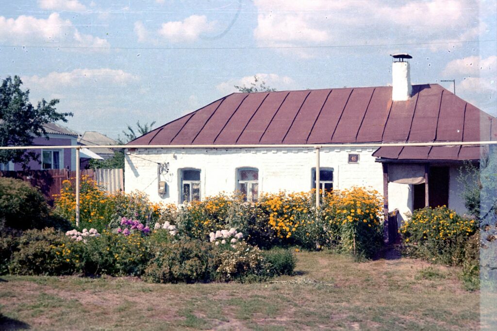 a small white house with a brown roof