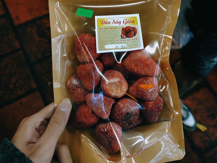 a person holding a bag of donuts in their hand