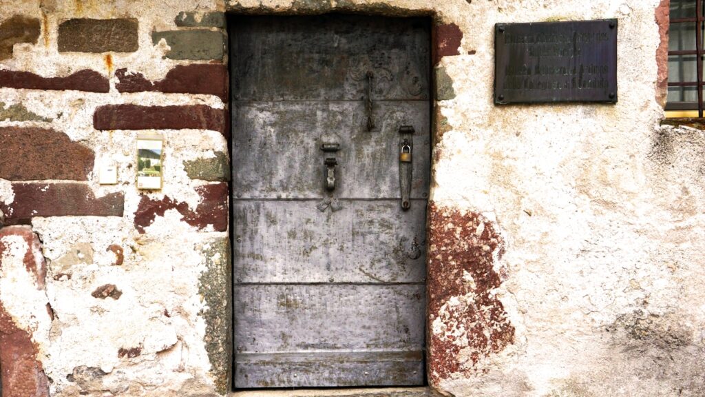 gray wooden door on white and brown concrete wall