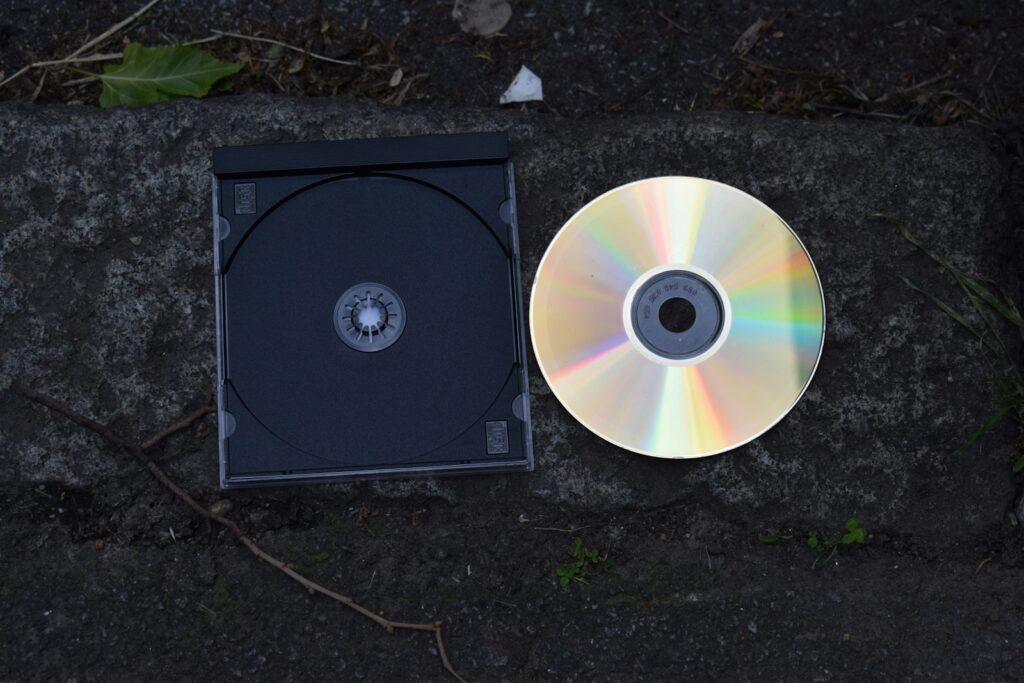 A cd and its case are on a stone surface.