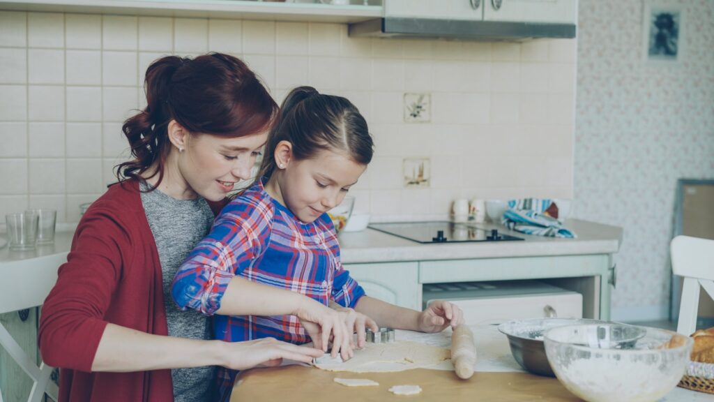 Mother and daughter bake together in the kitchen.