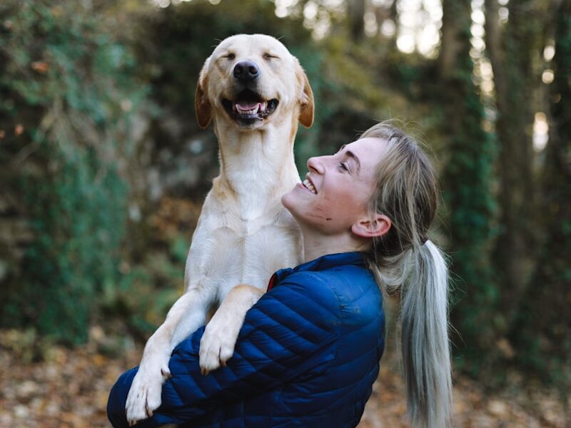 woman carrying dog while standing