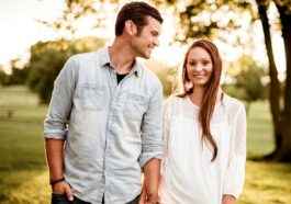man holding hand of woman standing near tree