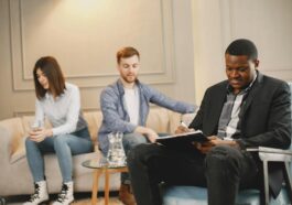 A couple discussing issues with a therapist during a counseling session indoors.