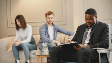 A couple discussing issues with a therapist during a counseling session indoors.