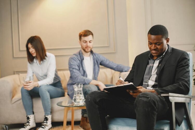 A couple discussing issues with a therapist during a counseling session indoors.