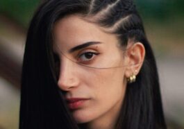 a woman with long black hair wearing a white shirt